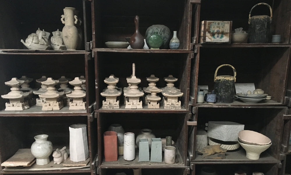 Estantes con cerámica japonesa en una tienda de alfarería, cuencos y teteras de distintos estilos