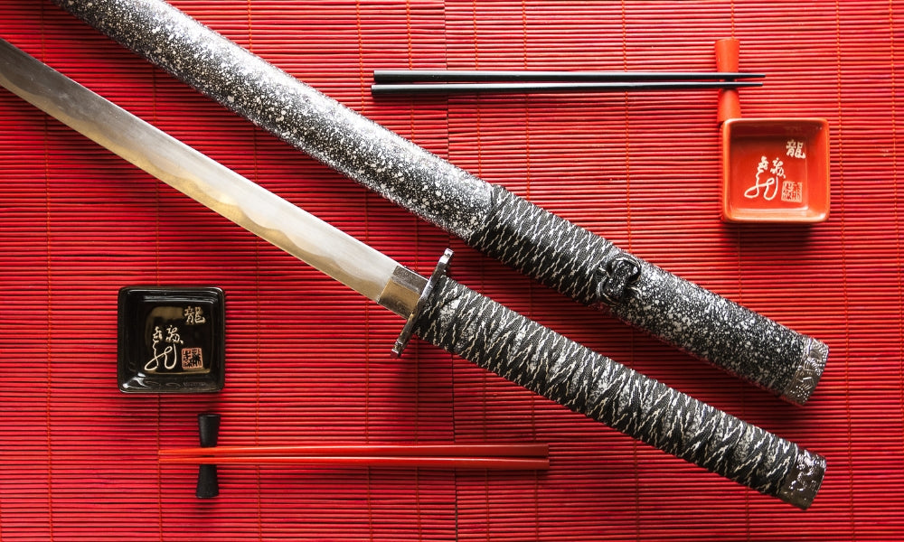 Katana japonesa tradicional sobre una estera de bambú roja: 1000 años de historia de la forja de espadas