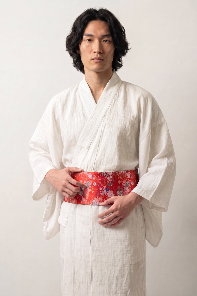 Colección de cinturones obi: hombre con kimono de lino blanco y cinturón obi rojo brocado con flores rosas, blancas y azules