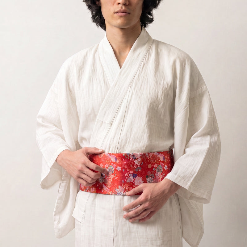 Colección de cinturones obi: hombre con kimono de lino blanco y cinturón obi rojo brocado con flores rosas, blancas y azules