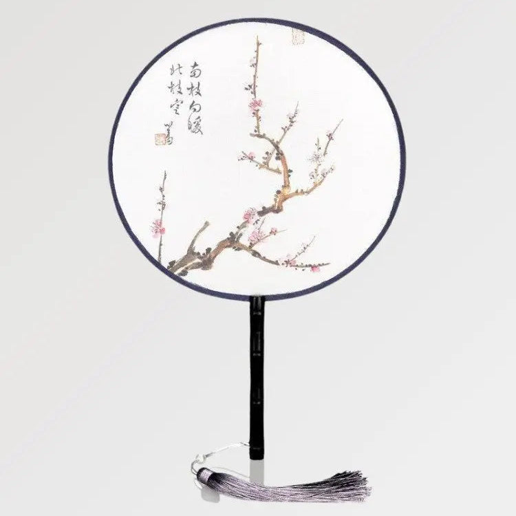 Abanico redondo con escrituras japonesas decorado con una rama donde crecen flores de sakura