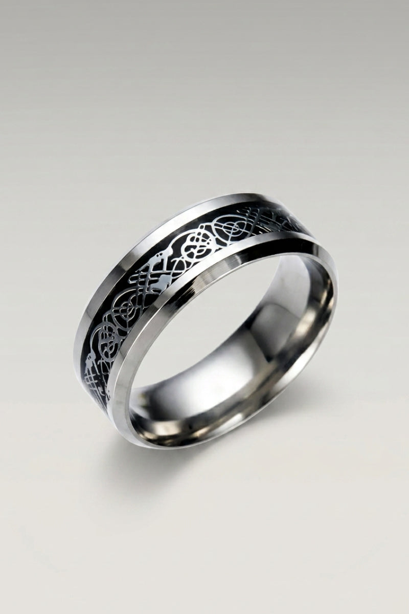 Anillo 'Ringshine' en negro — anillo plano de acero con banda central incrustada con un dragón filiforme, foto de producto sobre fondo gris claro