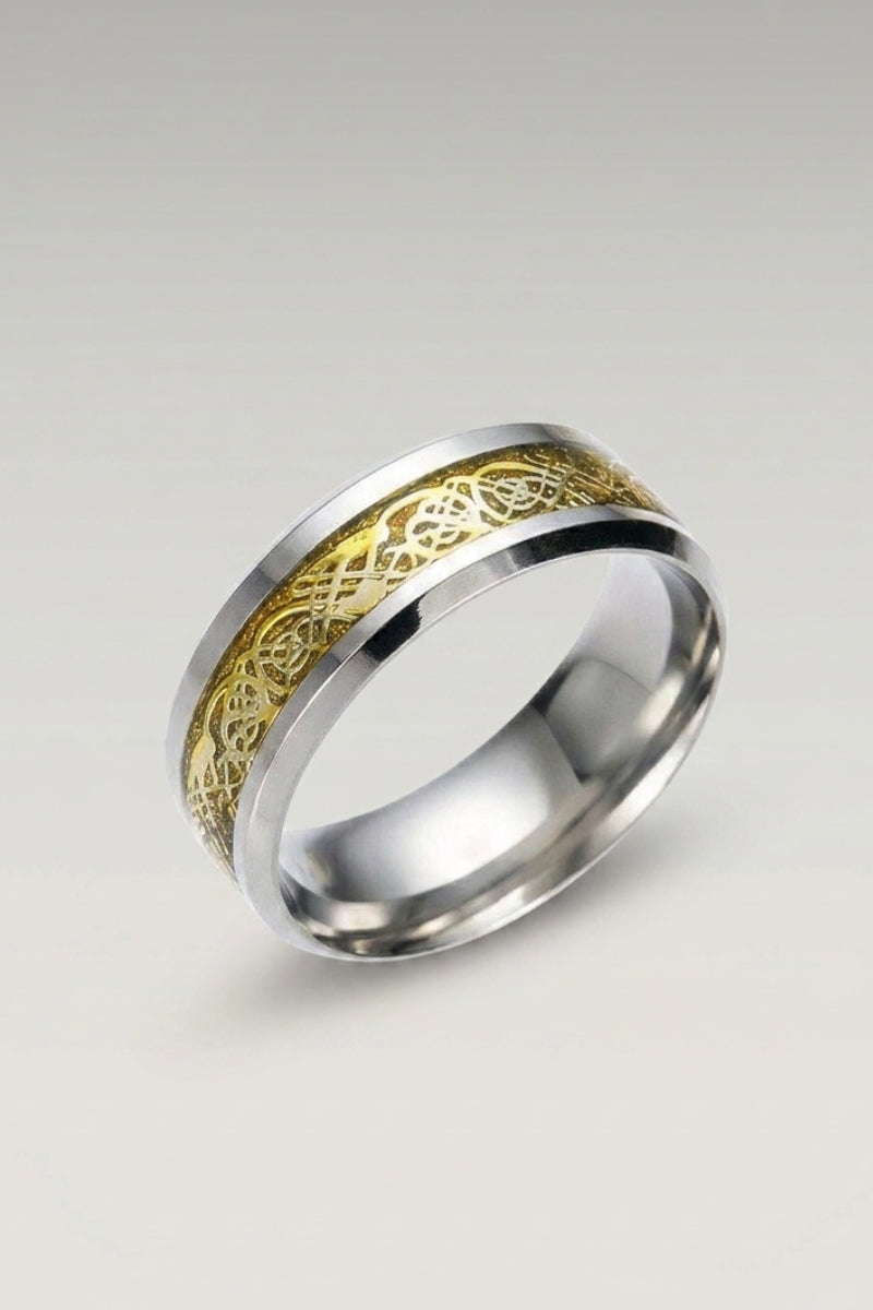 Anillo 'Ringshine' en oro — anillo plano de acero con banda central incrustada con un dragón filiforme, foto de producto sobre fondo gris claro