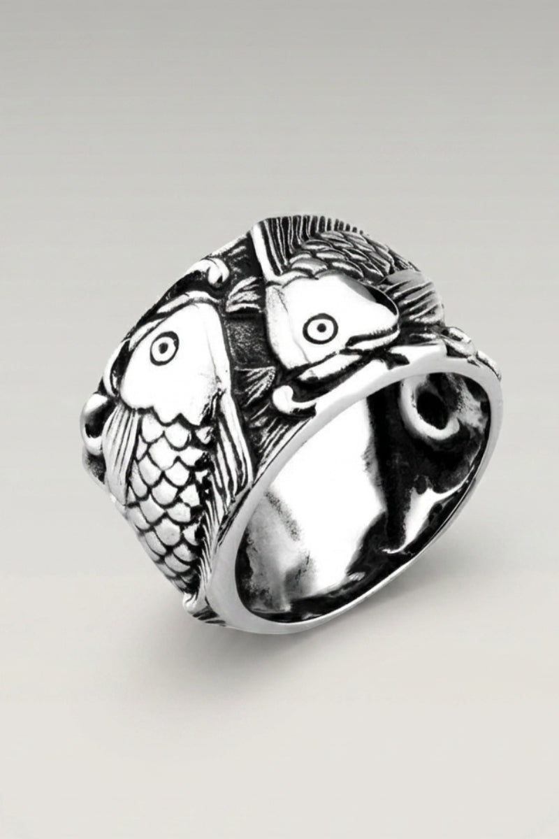 Anillo 'Akiruno' — anillo de sello con dos carpas enfrentadas que forman un círculo en blanco y negro, foto de producto sobre fondo gris claro