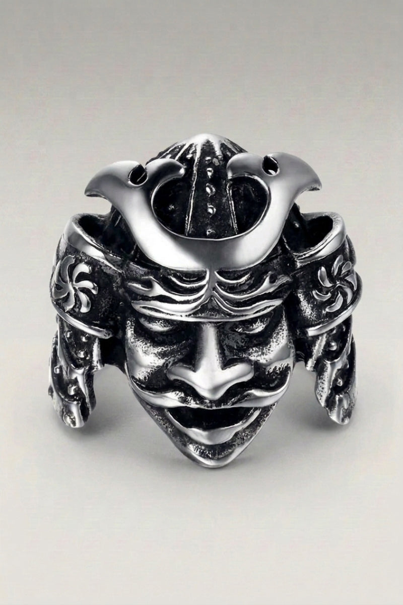 Anillo 'Otomail' — casco de guerrero tallado con cuernos laterales y máscara facial bajo la visera, foto de producto sobre fondo gris claro