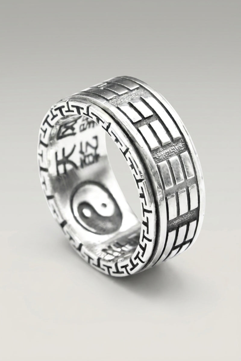 Anillo 'Kyoto Hono' en plata — anillo ancho con decoración grabada que mezcla círculo yin yang y motivo de ladrillos, foto de producto sobre fondo gris claro