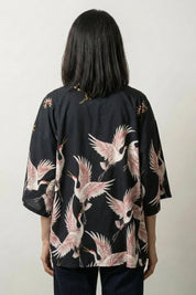 Chaqueta kimono corta para mujer Annaki negra vista trasera grullas blancas y rosas mangas tres cuartos streetwear japonés Ropa Japonesa