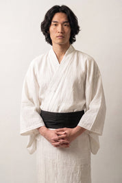 Cinturón obi 'Sapporo' ceñido a la cintura sobre un kimono blanco por un modelo masculino — negro profundo liso, de tejido cerrado y sin motivo