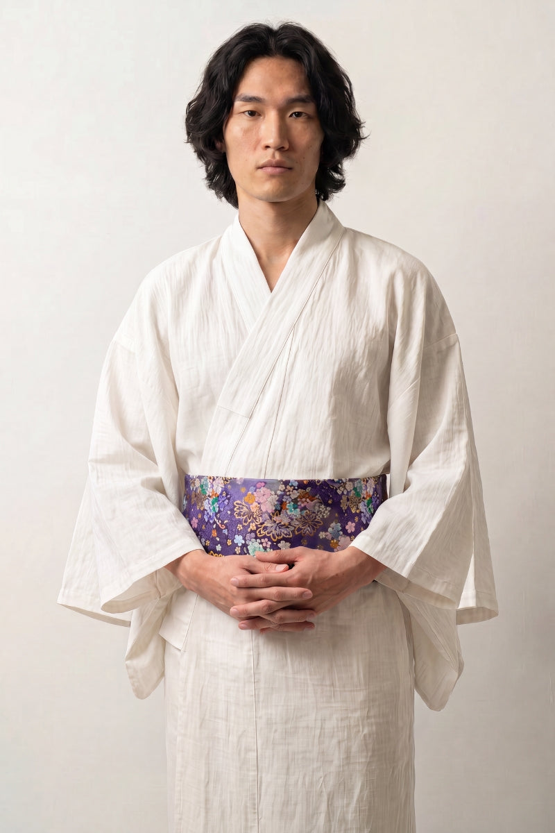 Cinturón obi 'Nadeshiko' sobre un kimono blanco por un modelo masculino — fondo violeta profundo cubierto de flores policromas realzadas en oro
