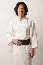 Cinturón obi 'Tokyo' ceñido a la cintura sobre un kimono blanco por un modelo masculino — marrón oscuro jaspeado con trama visible de relieve marcado