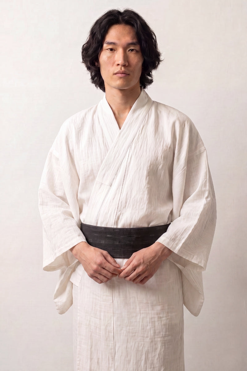 Cinturón obi 'Osaka' ceñido a la cintura sobre un kimono blanco por un modelo masculino — negro sembrado de trazos claros cortos dispuestos en líneas