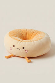 Cojín japonés 'Itami' con los ojos cerrados — cojín de suelo de peluche crema con forma de personaje de mejillas rosas, centro hundido naranja y piecitos