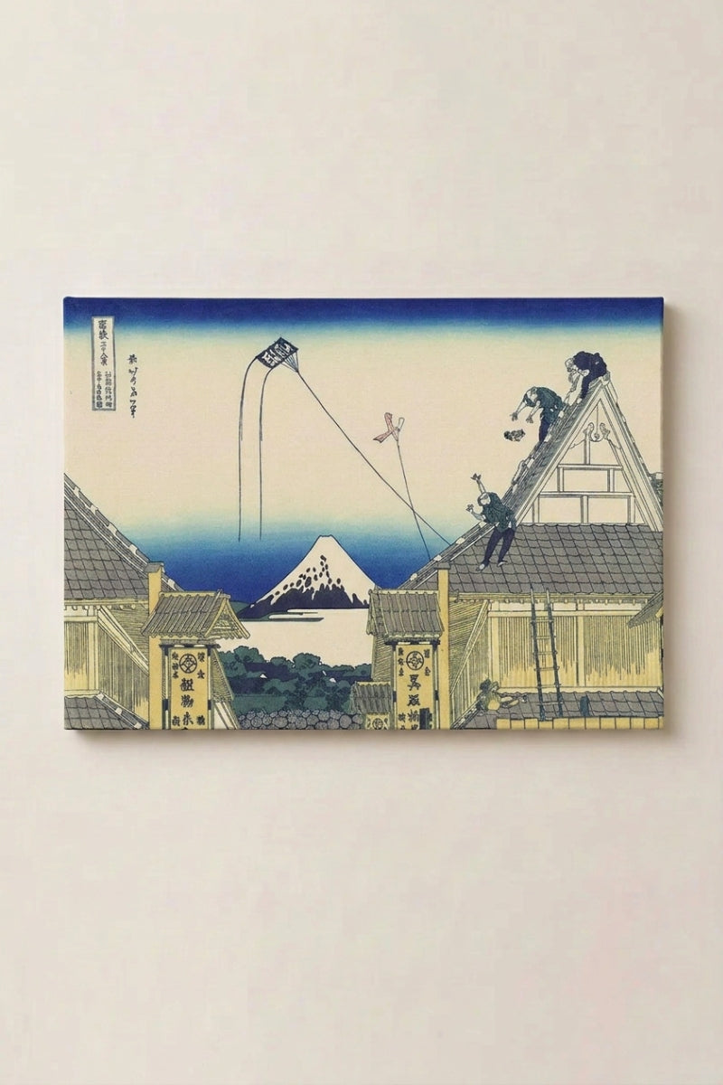 Grabado japonés 'Heiwa-teki' en panel enmarcado sobre pared beige — tejados y andamios de un barrio en obras y el Fuji nevado entre las armaduras de madera