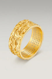 Anillo 'Kumo' en oro — anillo ancho con volutas de nubes talladas en relieve en toda la circunferencia, foto de producto sobre fondo gris claro