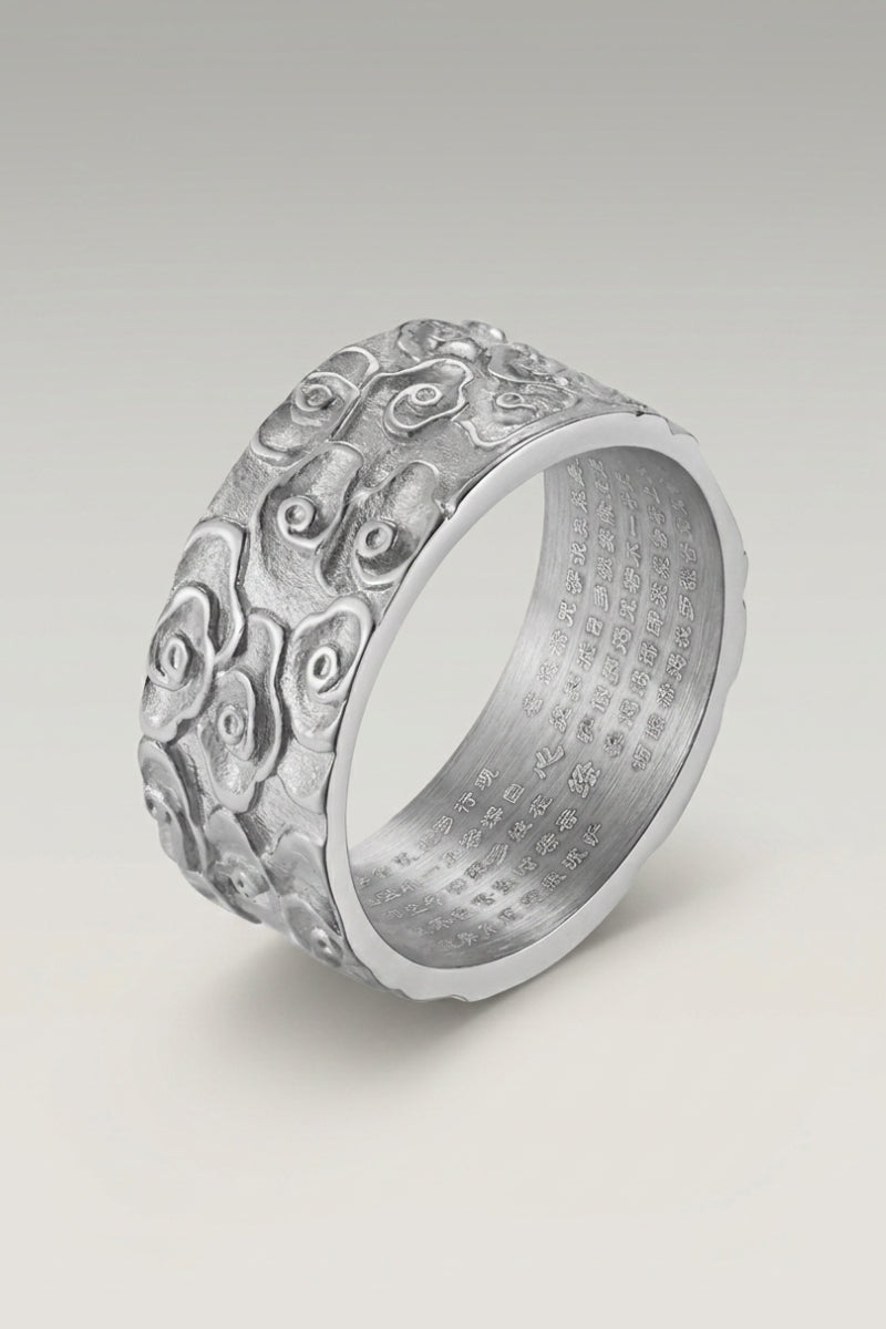 Anillo 'Kumo' en plata — anillo ancho con volutas de nubes talladas en relieve en toda la circunferencia, foto de producto sobre fondo gris claro