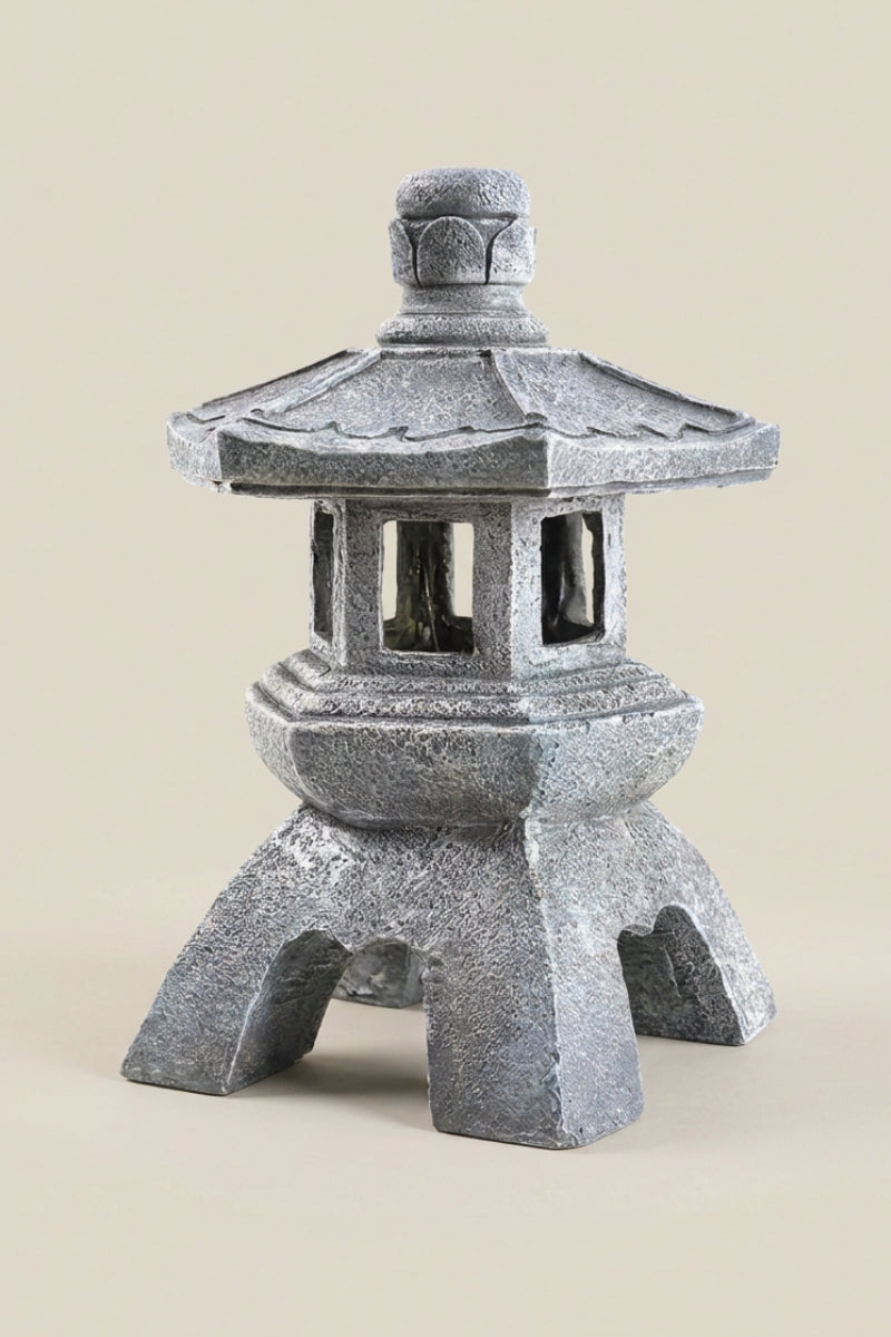 Farol japonés — farol de exterior en piedra gris con tejado hexagonal escalonado, ventanas con travesaños y patas arqueadas, foto sobre fondo beige