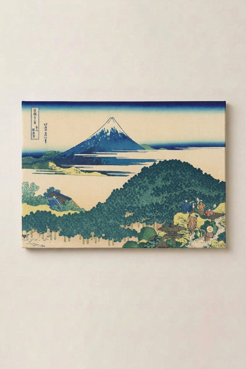 Grabado japonés 'Akigo' presentado como panel enmarcado en una pared beige — monte Fuji azul profundo surgiendo tras una colina densamente arbolada, cielo claro