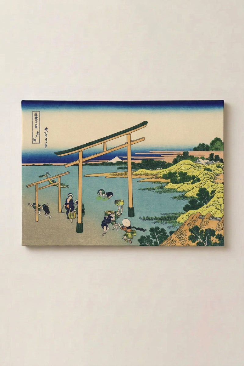 Grabado japonés 'Torii' en panel enmarcado sobre pared beige — torii clavado en la orilla al crepúsculo ocre, pescadores en el agua baja y el Fuji al fondo
