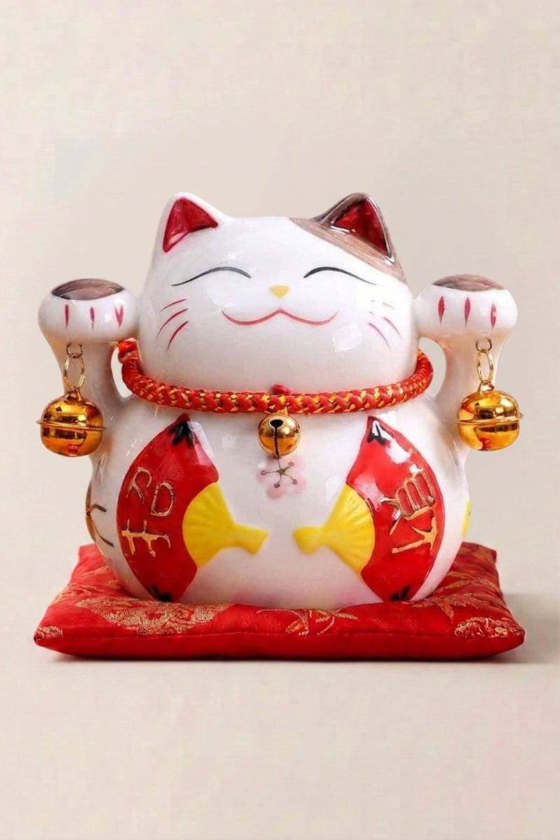Hucha maneki neko 'Fans' de cerámica — gato blanco de vientre rojo sosteniendo un abanico dorado, decoración de flores y monedas, sobre un cojín rojo