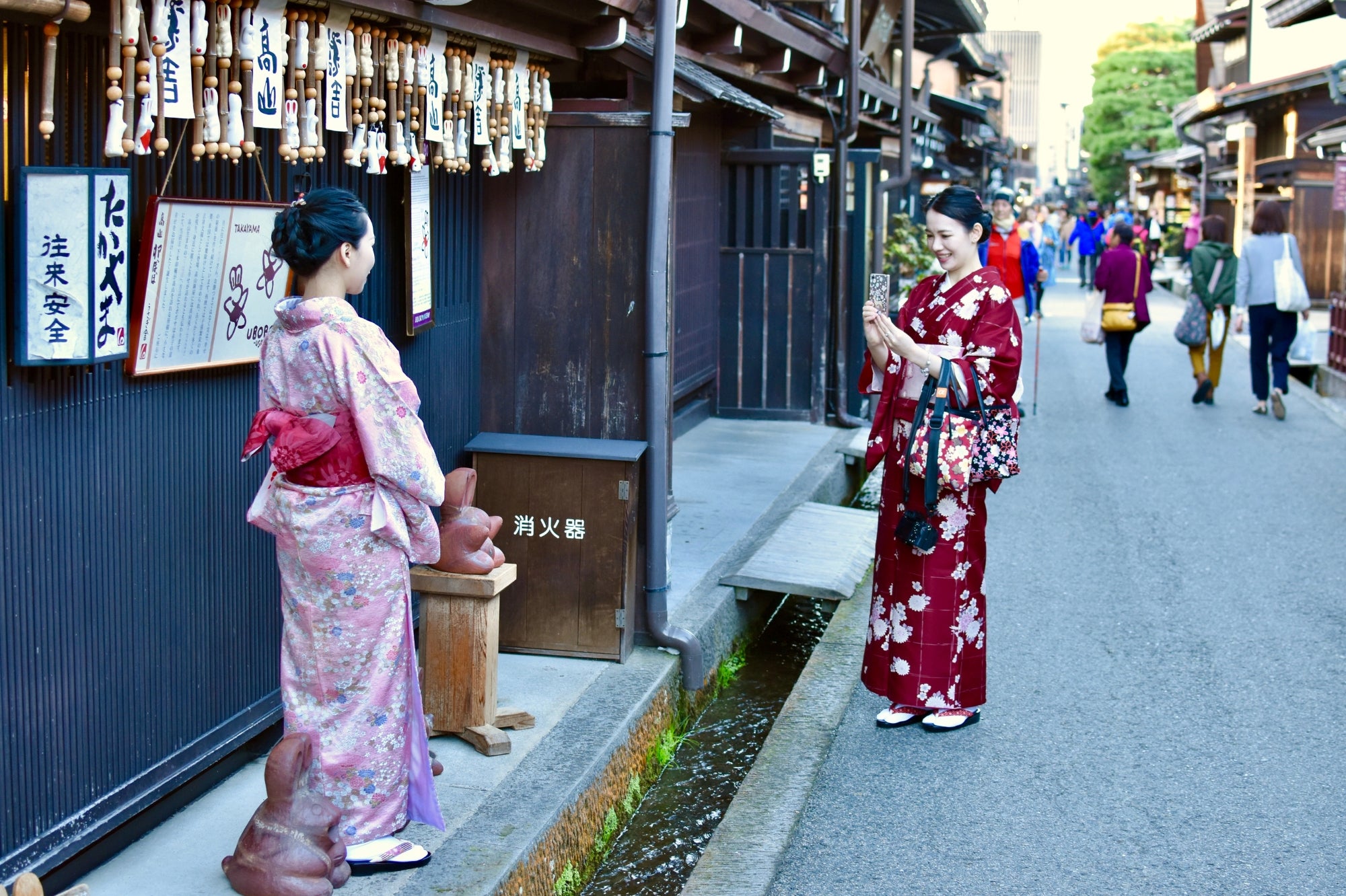 Dos mujeres vestidas con kimono posan para una foto en una calle tradicional del barrio de Gion en Kioto, en el corazón de la cultura japonesa.