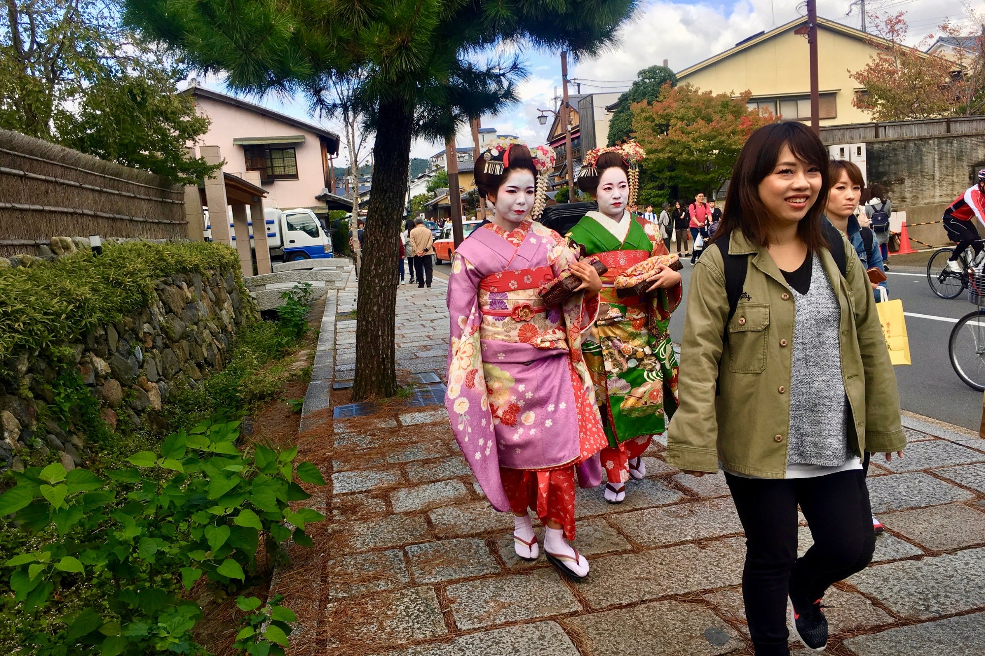 Dos mujeres vestidas con kimono posan para una foto en una calle tradicional del barrio de Gion en Kioto, en el corazón de la cultura japonesa.