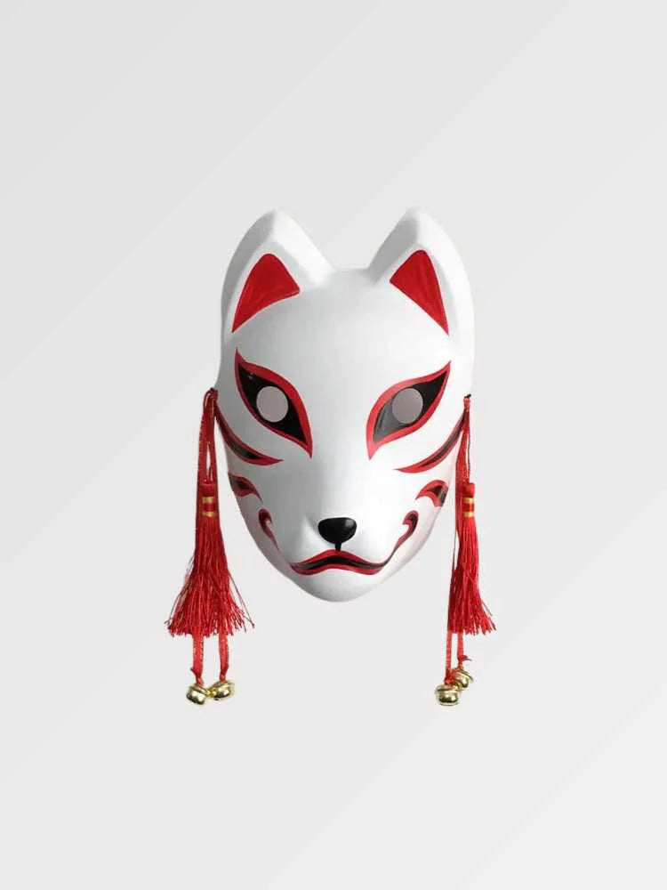Máscara kitsune roja y blanca presentada de frente sobre fondo gris liso — zorro blanco con trazos rojos, borlas rojas y cascabeles dorados a los lados