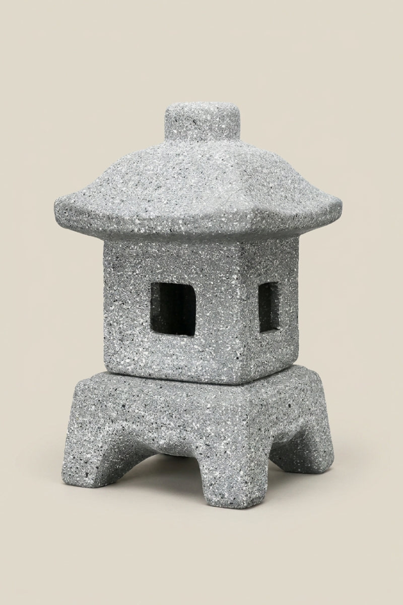 Farol japonés — farol de jardín en piedra gris con tejado cuadrado, cuatro patas arqueadas y aberturas rectangulares, foto de producto sobre fondo beige liso