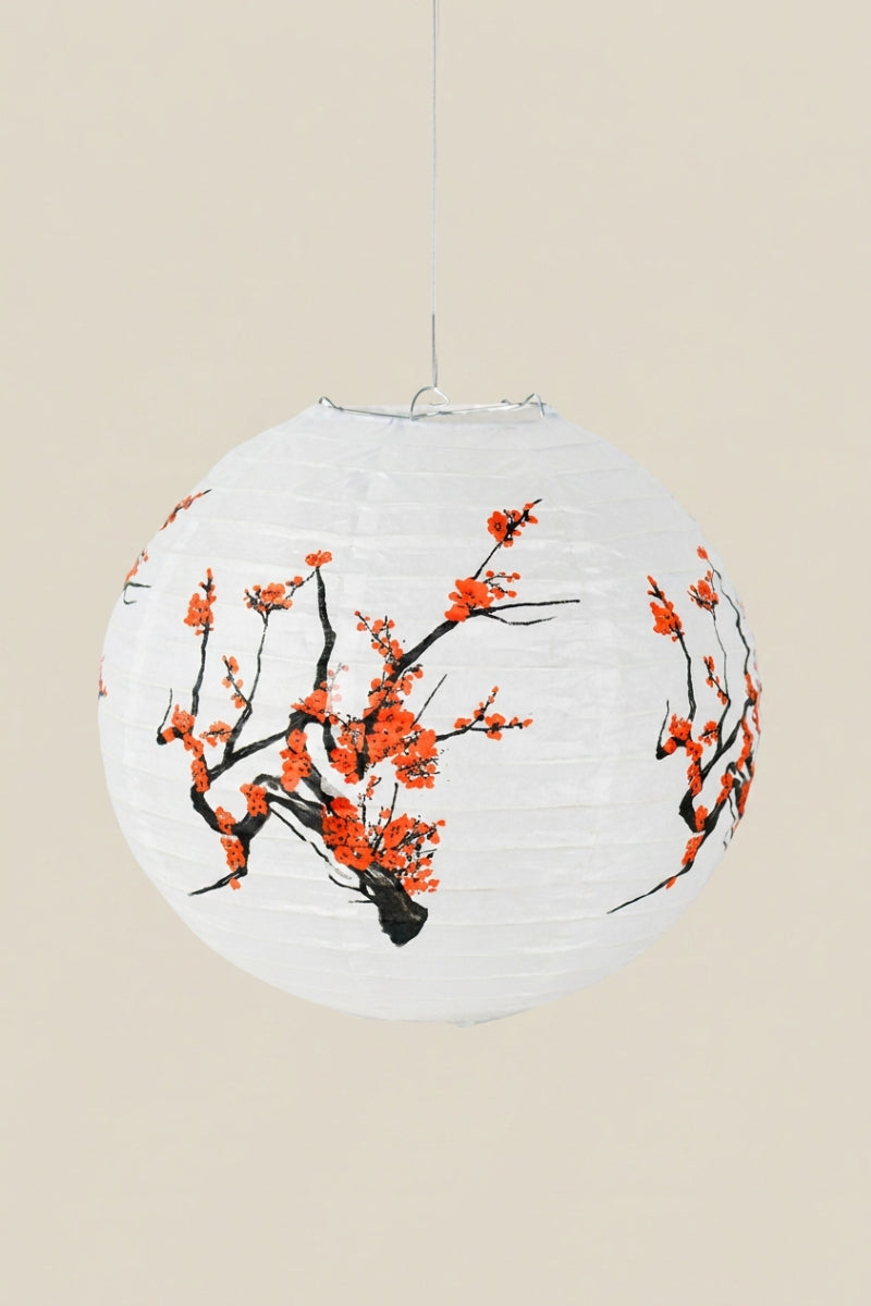 Farol japonés color sakura — farol esférico de papel blanco con ramas de ciruelo de flores rojo anaranjado, colgado de un hilo sobre fondo beige liso