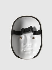 Máscara de nô vista de tres cuartos por detrás — rostro femenino blanco lacado, labios rojos y cejas altas pintadas, interior hueco visible