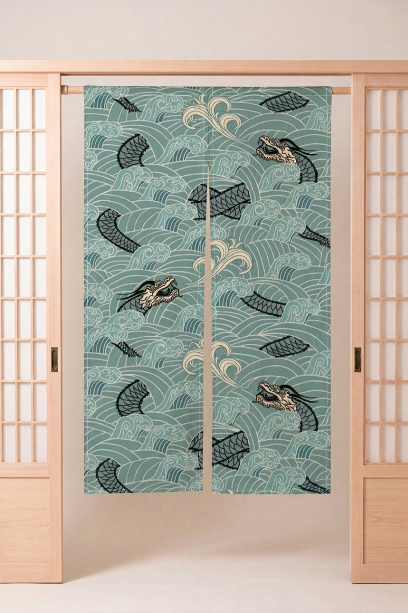 Noren japonés 'Ryu-jin' colgado en el marco de una puerta de madera clara — peces oscuros nadando entre remolinos blancos sobre fondo verde agua pálido