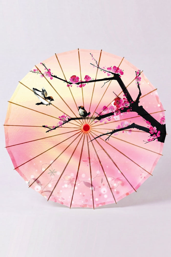 Sombrilla japonesa 'Sakura Fleuri' vista desde abajo — tela rosa en degradado con rama oscura y flores de cerezo, armazón a la vista