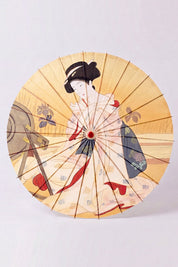 Sombrilla japonesa 'Take-Amino' vista desde arriba, abierta en plano — tela amarillo ocre con retrato de mujer en kimono al gusto de la estampa