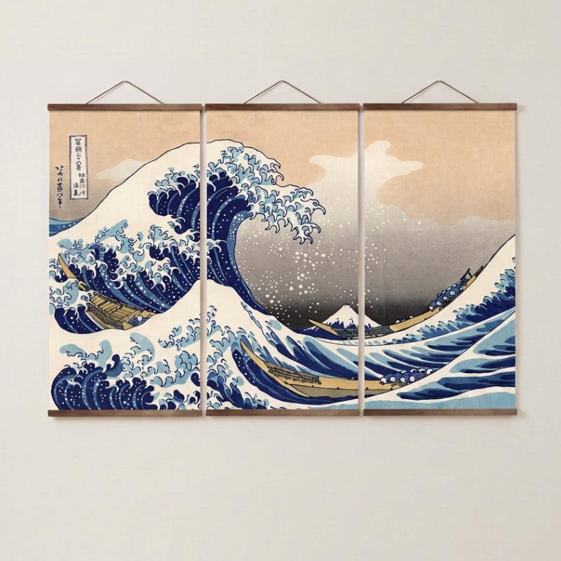 Tríptico japonés 'Kanagawa' colgado en una pared beige — la gran ola de Hokusai repartida en tres paneles con listones de madera clara