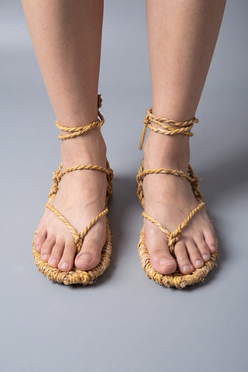 Sandalias waraji descalzas, vista frontal: suelas de paja trenzada con cuerdas cruzadas sobre el empeine
