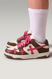 Zapatillas bajas 'Shiro' en rojo — cruces en relieve en los laterales y cordones gruesos a juego, con calcetines blancos sobre fondo de estudio gris