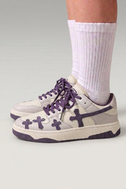Zapatillas bajas 'Shiro' en violeta — cruces en relieve en los laterales y cordones gruesos a juego, con calcetines blancos sobre fondo de estudio gris