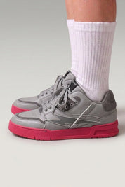 Zapatillas chunky 'Inazuma' en rosa — corte blanco y gris sobre una suela monocroma viva, con calcetines blancos sobre fondo de estudio gris