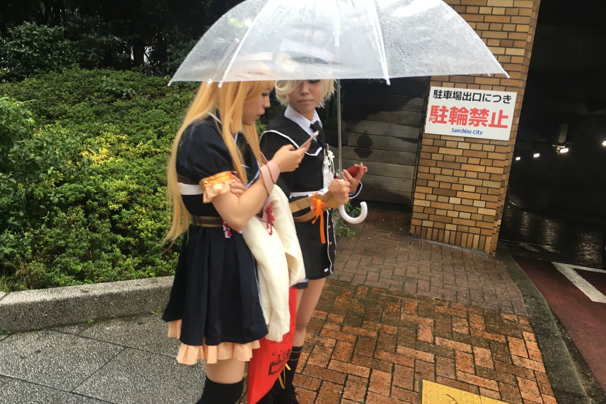Dos jóvenes cosplayers bajo un paraguas en Sunshine City, Tokio, representando la creatividad y el universo del cosplay japonés.