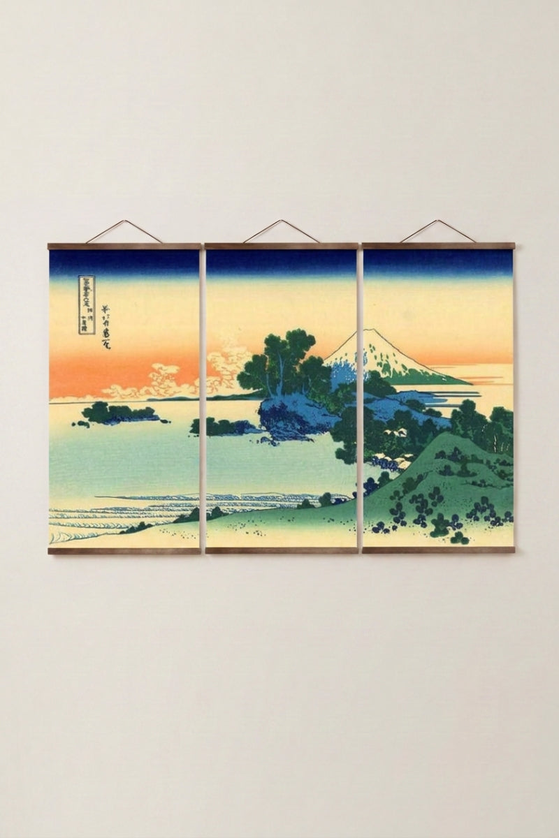 Tríptico japonés 'Aka Machi' colgado en una pared beige — monte Fuji al atardecer tras agua turquesa y pinos, en tres paneles