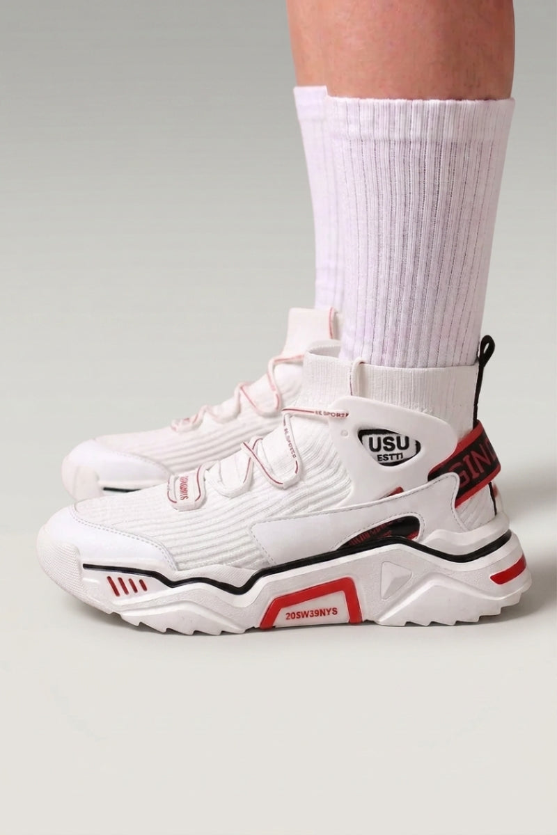 Zapatillas altas 'Echizen' en blanco — dos correas anchas, cuello acolchado y detalles rojos, con calcetines blancos sobre fondo de estudio gris